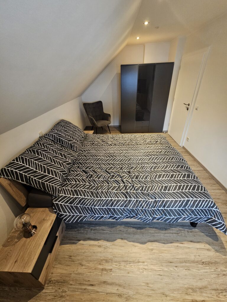 Doppelbett mit Kleiderschrank und Sessel