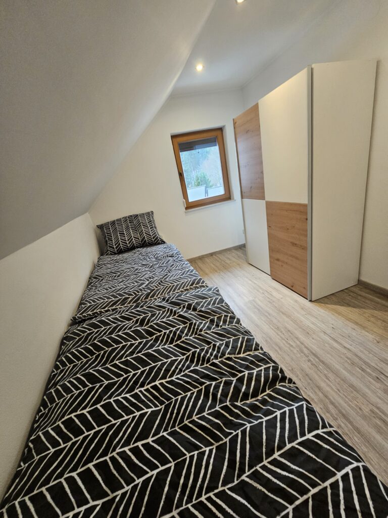 Einzelbetten unter der Dachschräge mit Kleiderschrank